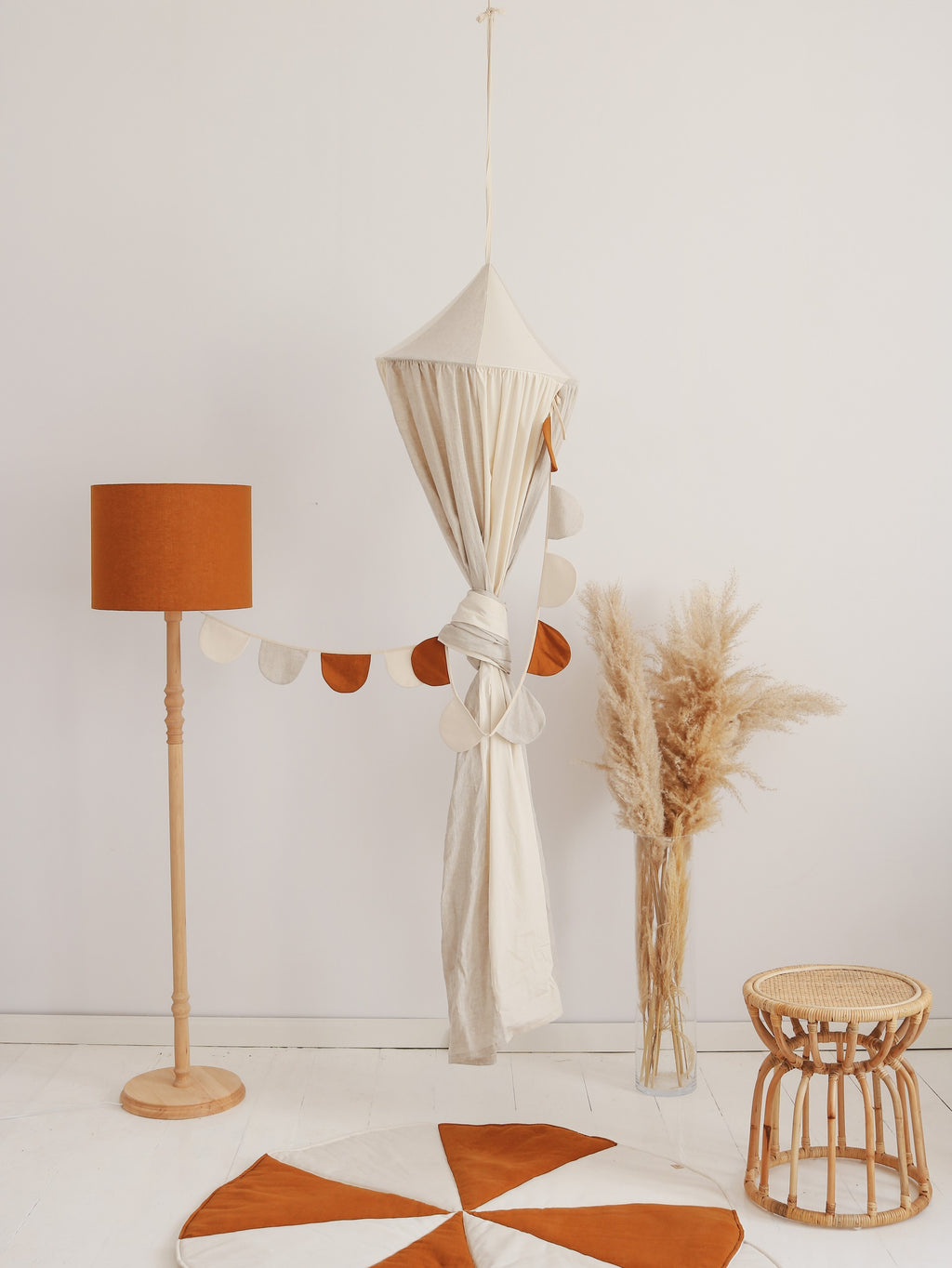 cream circus organic cotton and linen canopy hanging gracefully over a cozy reading nook with soft natural light