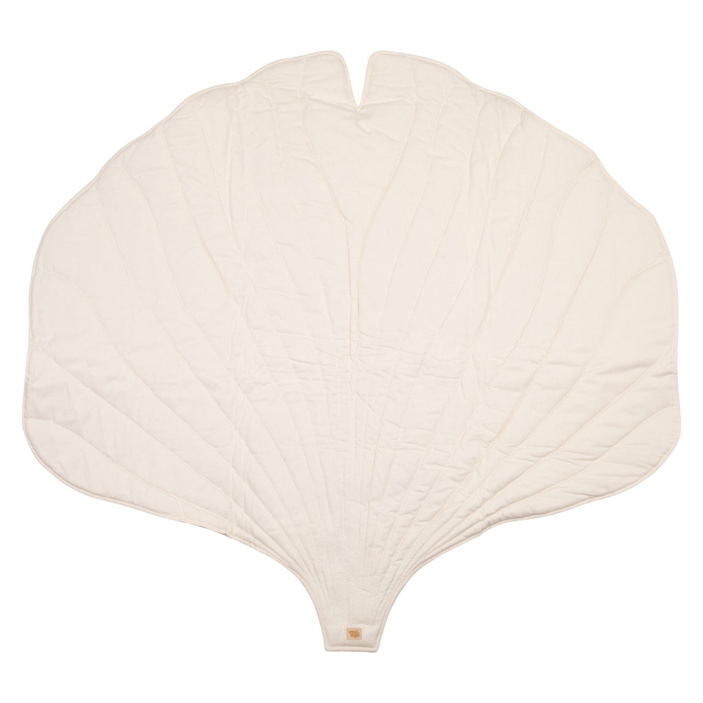 handmade ginkgo leaf playmat on a wooden floor, showcasing its soft cream texture and elegant double-sided design