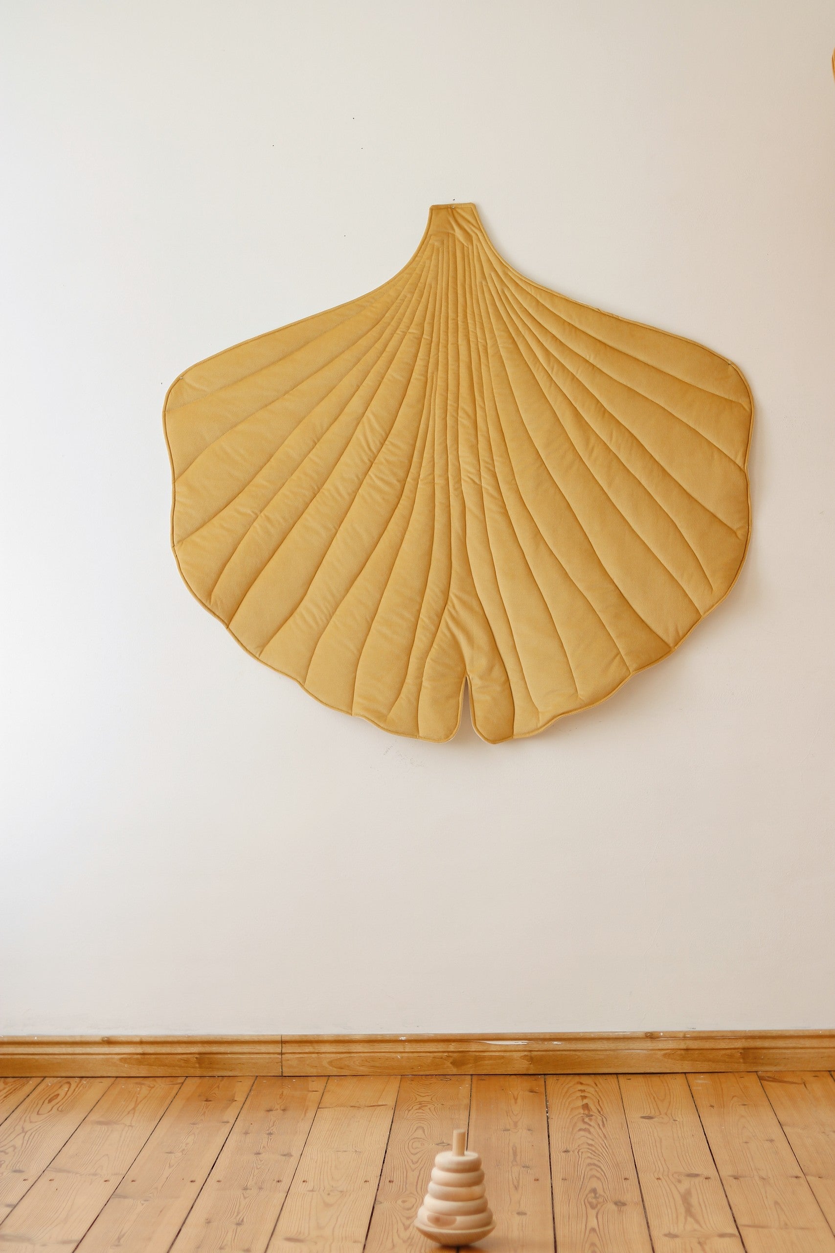 a soft yellow ginkgo leaf playmat with cozy velvet texture, perfect for a child's quiet time
