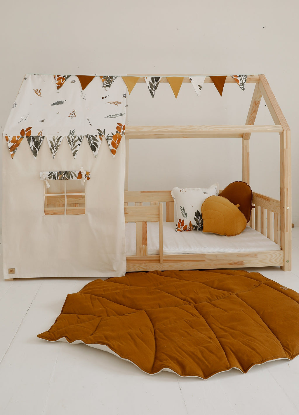 elegant caramel leaf playmat on a wooden floor, showcasing its artisan stitching and refined reversible design