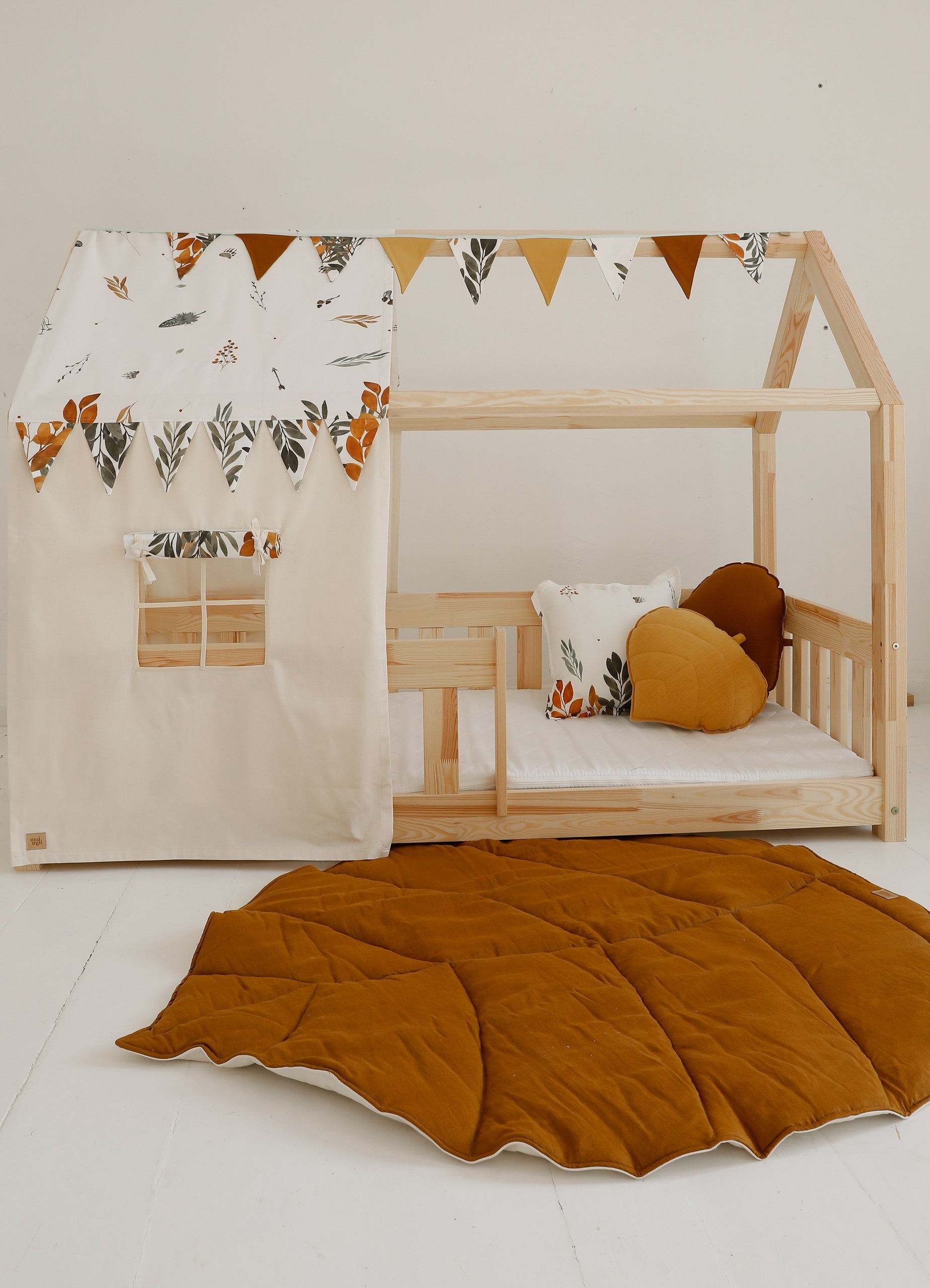 elegant caramel leaf playmat on a wooden floor, showcasing its artisan stitching and refined reversible design