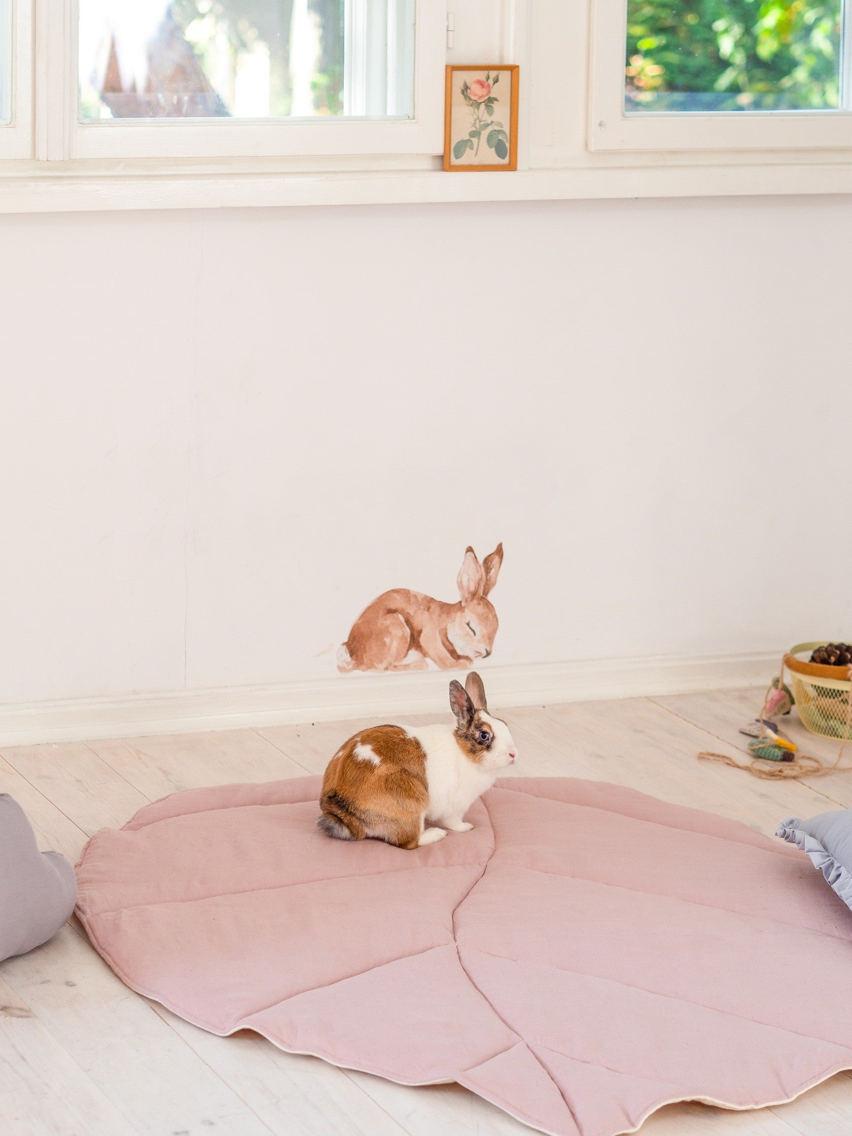 elegant powder pink leaf playmat on a polished wood floor, showcasing artisan linen texture