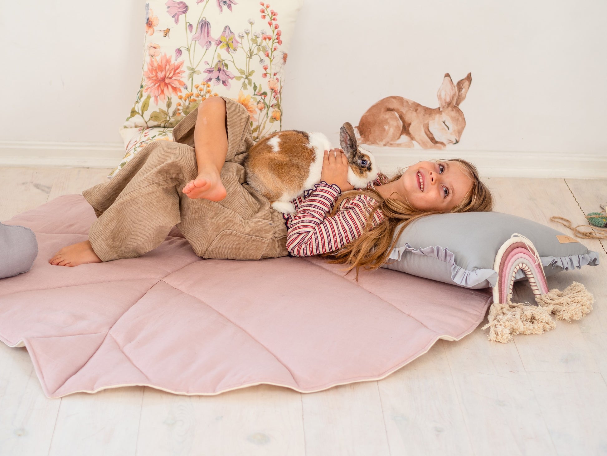 a playful powder pink leaf playmat with a toddler giggling during a backyard picnic