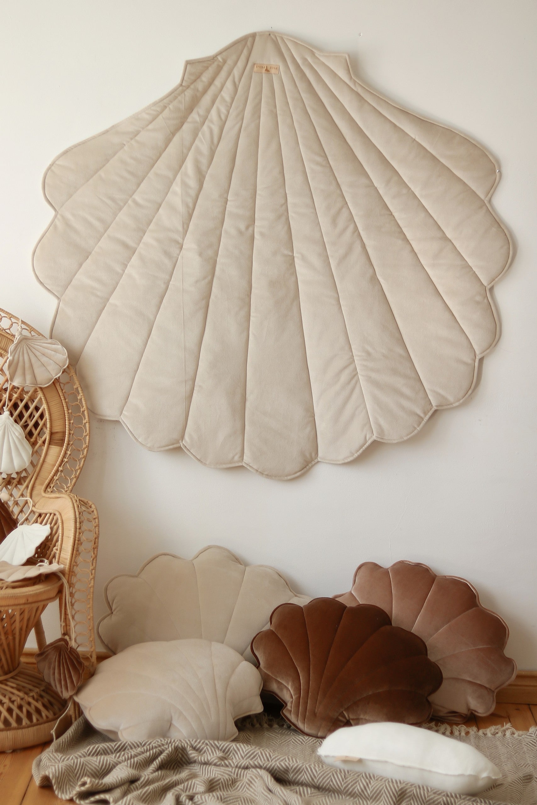 handmade beige ginkgo leaf playmat on a wooden floor in soft morning light