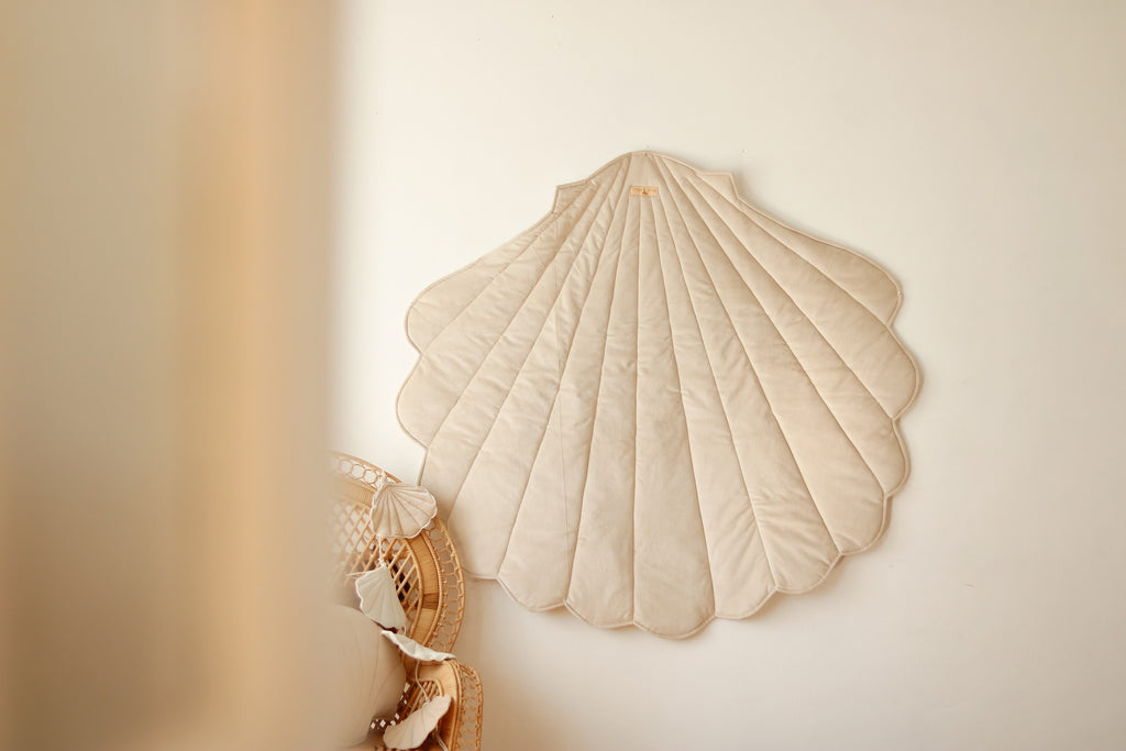 beige organic cotton and velvet ginkgo leaf playmat laid on grass under dappled sunlight, soft and inviting