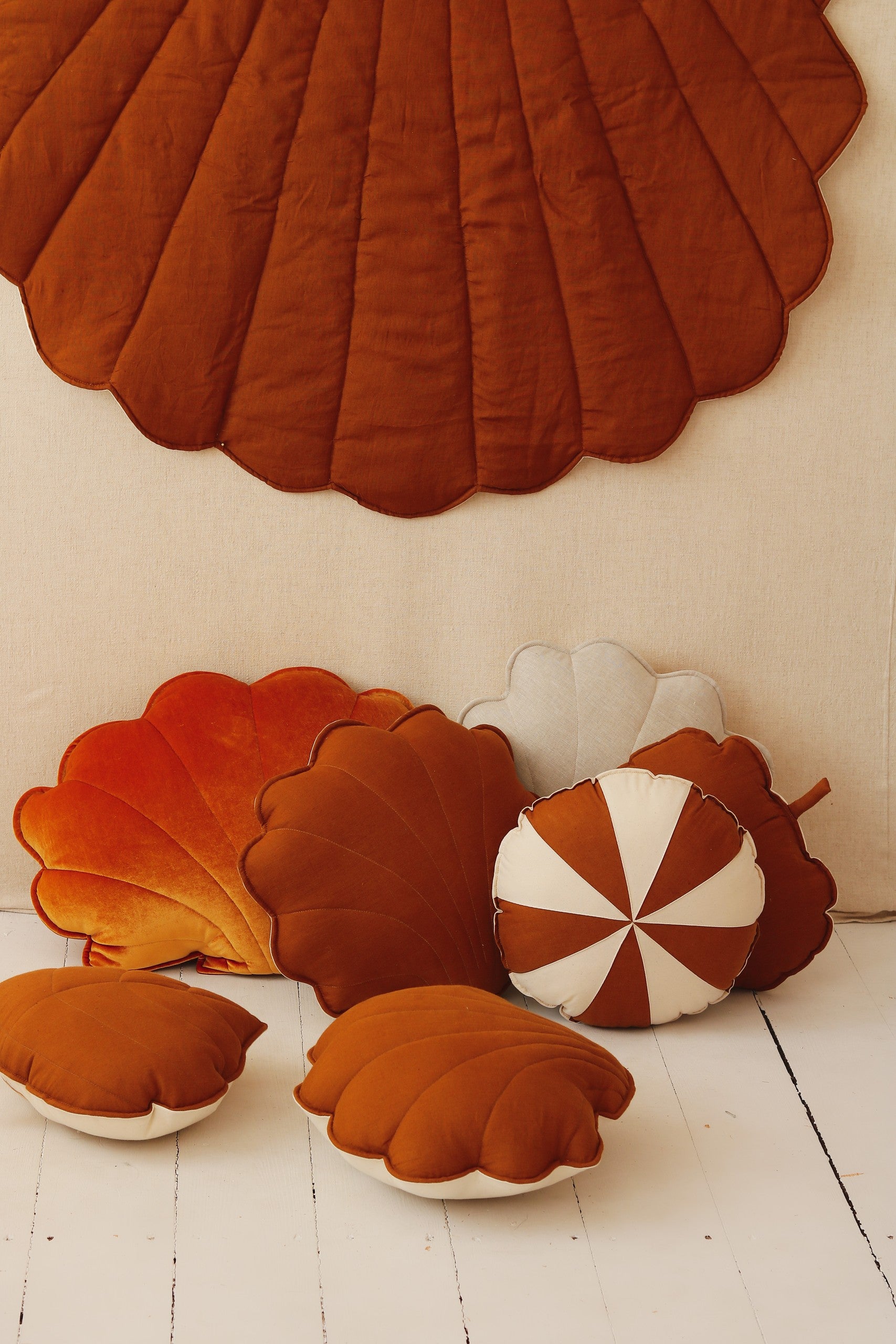 a playful toddler giggling on a soft caramel ginkgo leaf playmat in a sunny garden