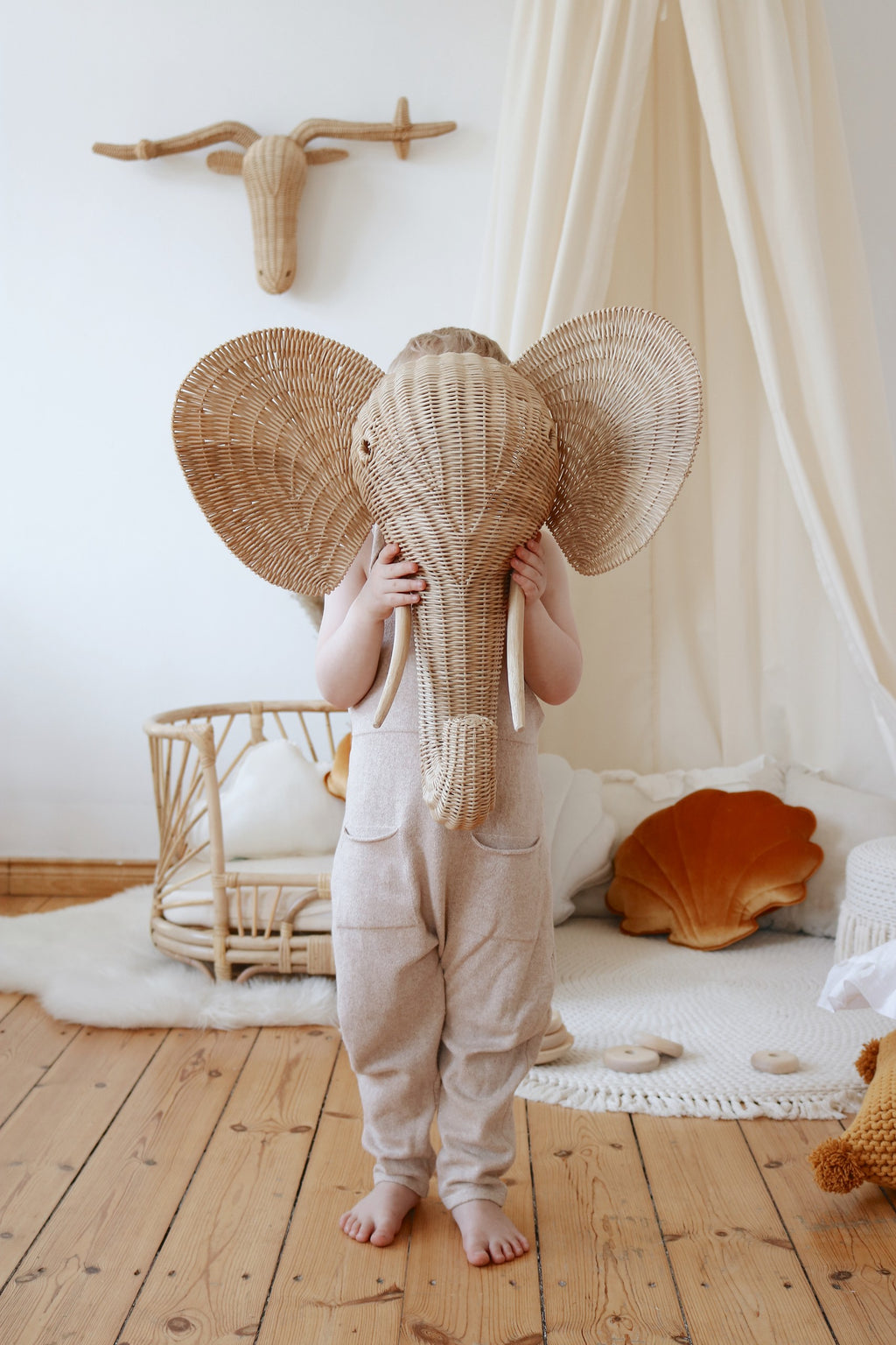 organic cotton canopy hanging over a cozy reading nook with soft natural light filtering through