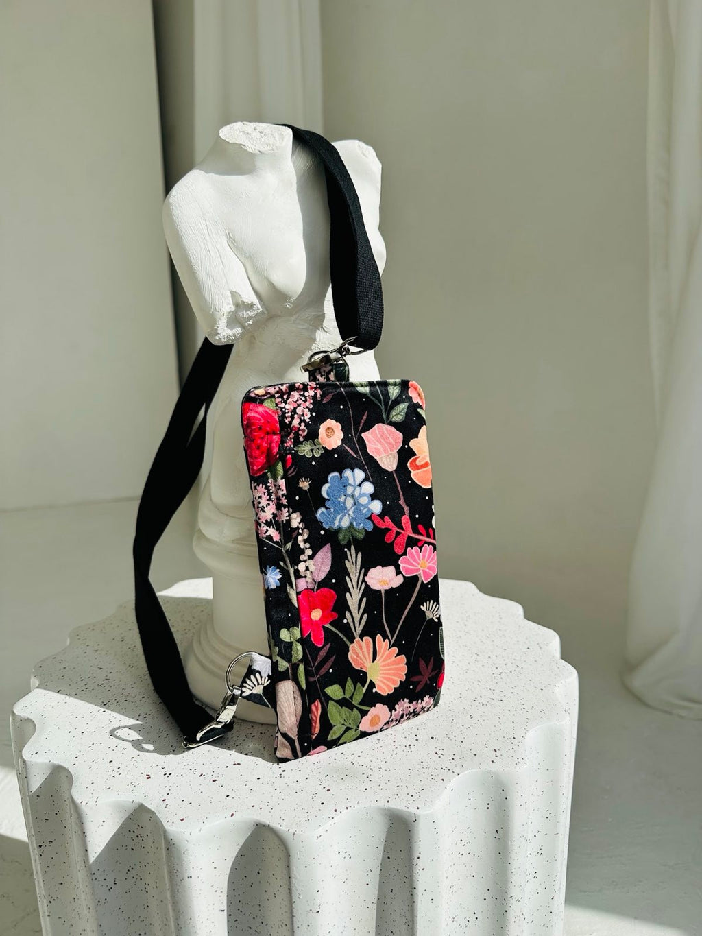 soft velour phone bag with a metal press clasp and front zipper pocket, shown in a comforting close-up