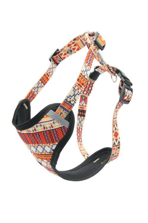 a playful dog modeling the boho style pressure free harness in a sunlit garden