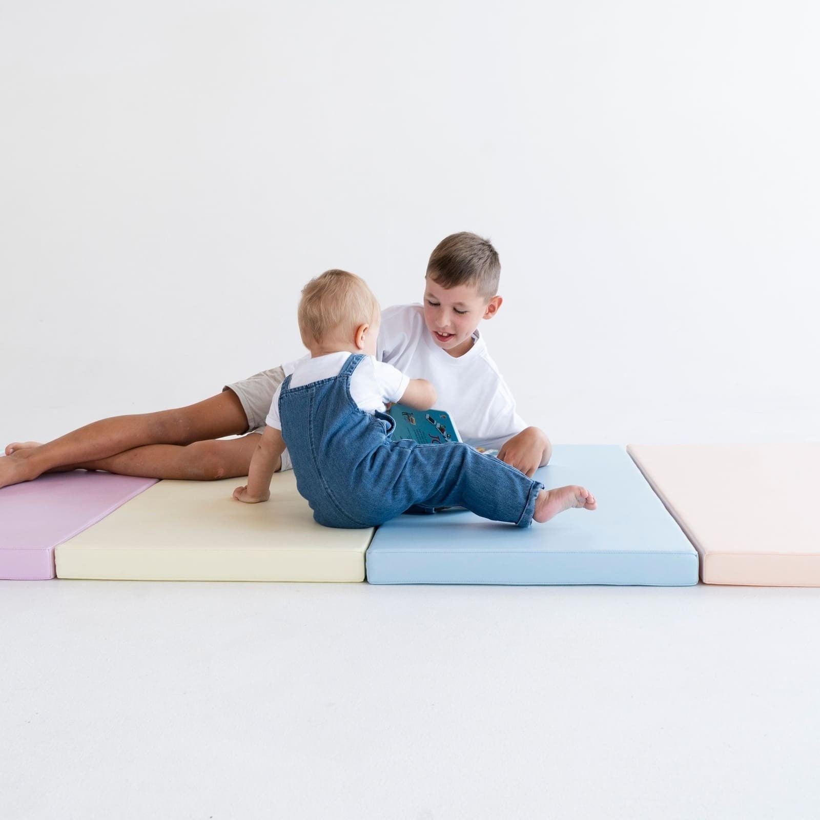 pastel play mats stacked in a sunny nursery, inviting toddlers to crawl and explore safely