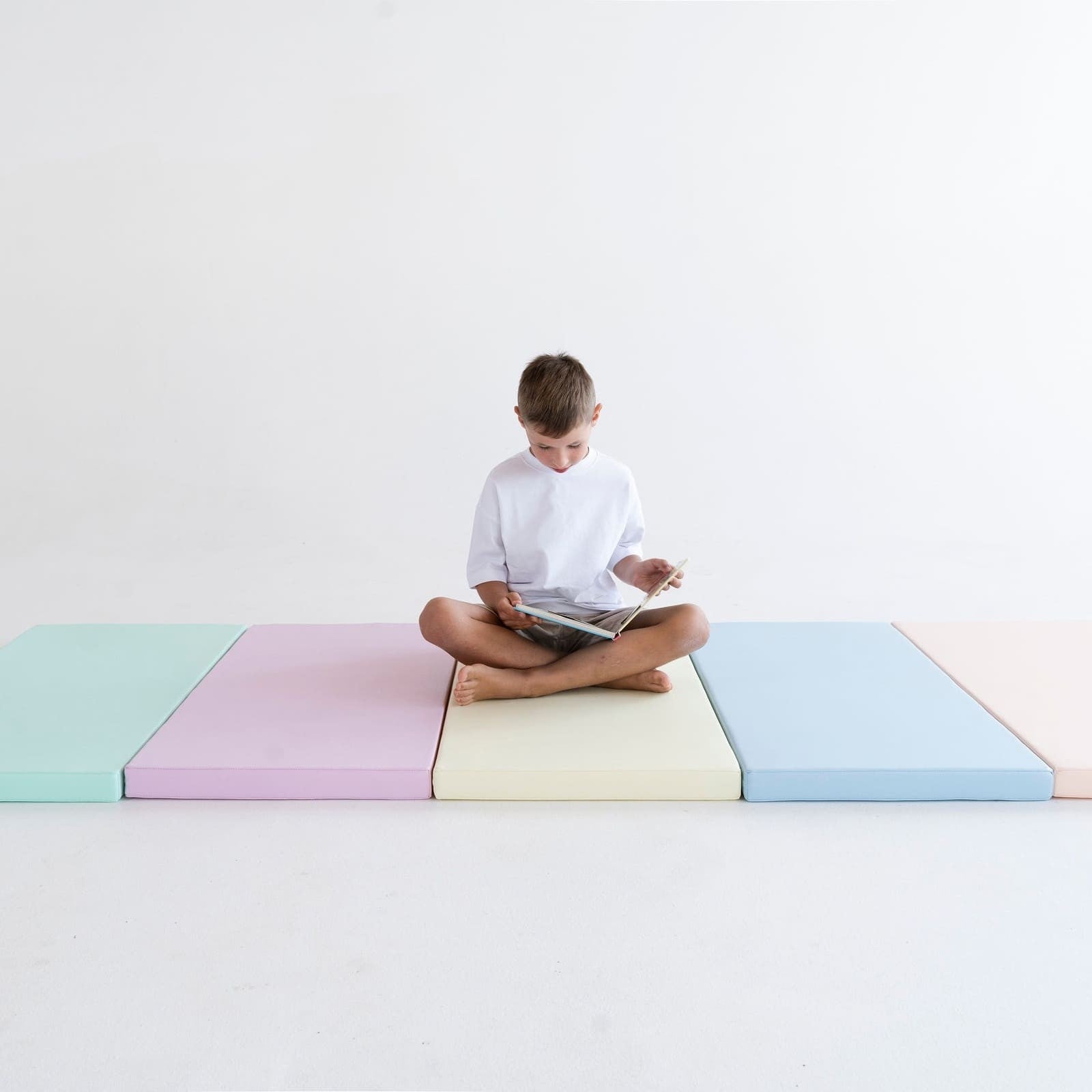 pastel 5-mat set arranged in a playful pattern on a cozy nursery floor, perfect for safe crawling and imaginative play