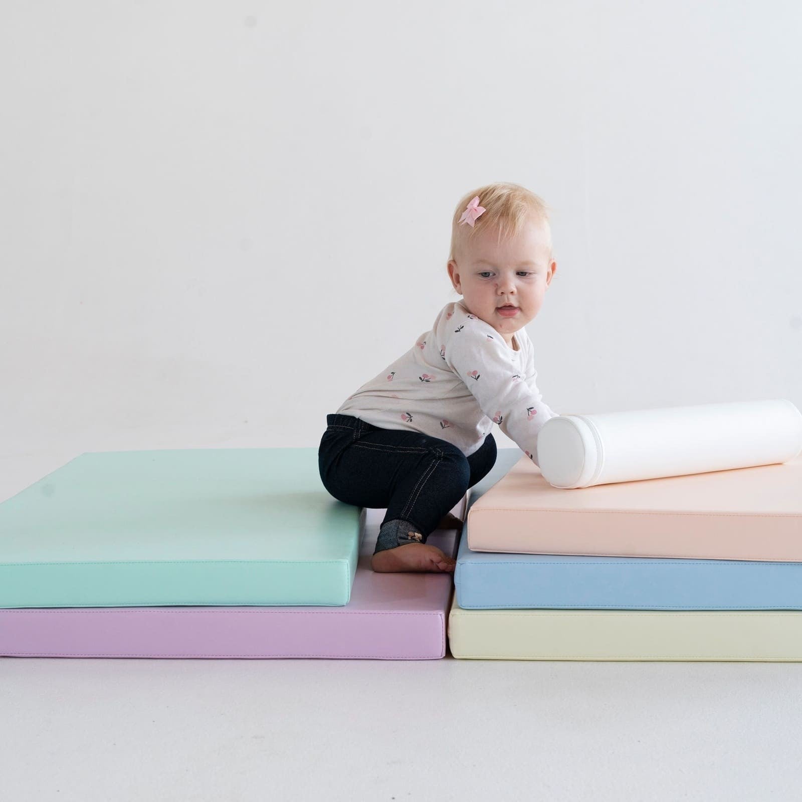 pastel foam play mats stacked in soft sunlight, perfect for safe toddler play and cozy naptime