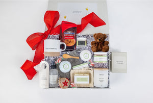 softly lit luxury spa gift set with a cozy teddy bear and ceramic mug on a calming background