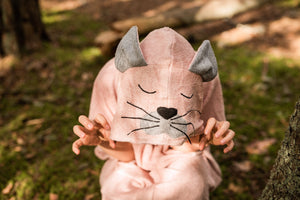 a child wrapped in a soft bamboo terry poncho, cozy hood up and hands tucked into warm pockets