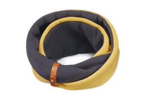 soft golden neck warmer with a leather belt on a dog in cozy indoor light