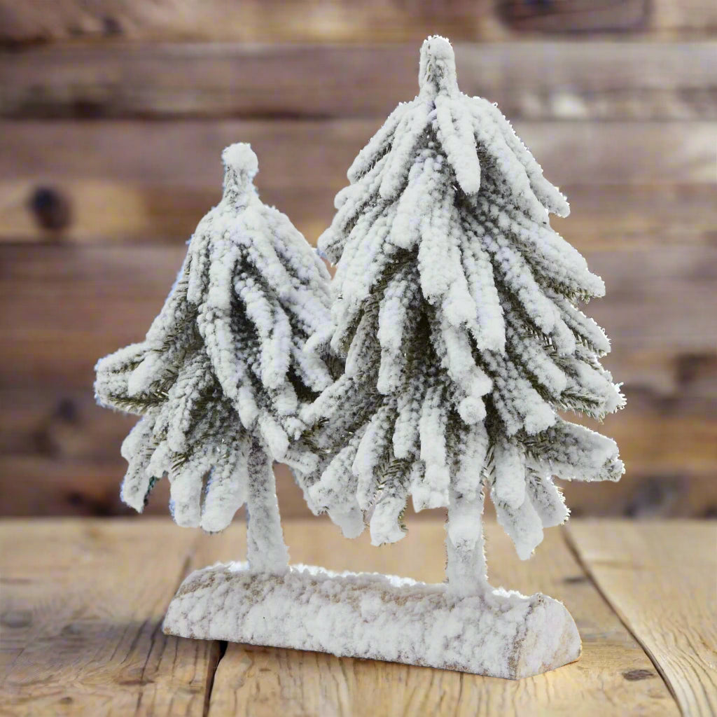 Snow-dusted fir tree duo on wooden base, perfect for winter decor and holiday centerpieces by Sostter at brixbailey.com