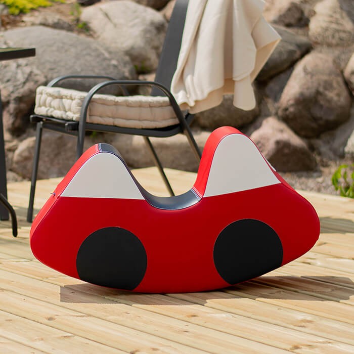 vibrant red soft play ride-on car for toddlers, promoting balance and imagination in a cozy home setting