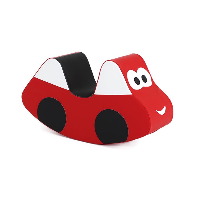 smiling toddler riding a bright red soft play car, giggling as they rock back and forth on a cozy rug