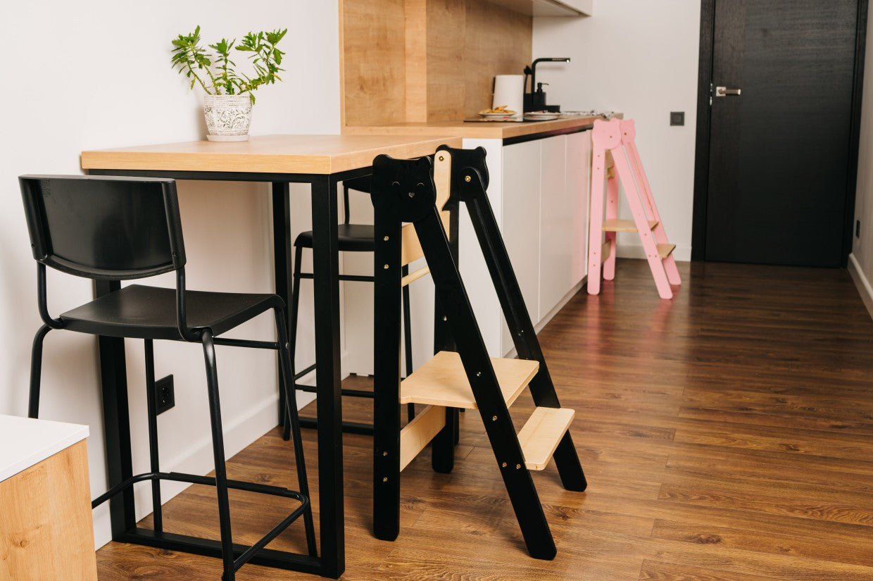 foldable baltic birch step stool folded flat against a wall for compact storage
