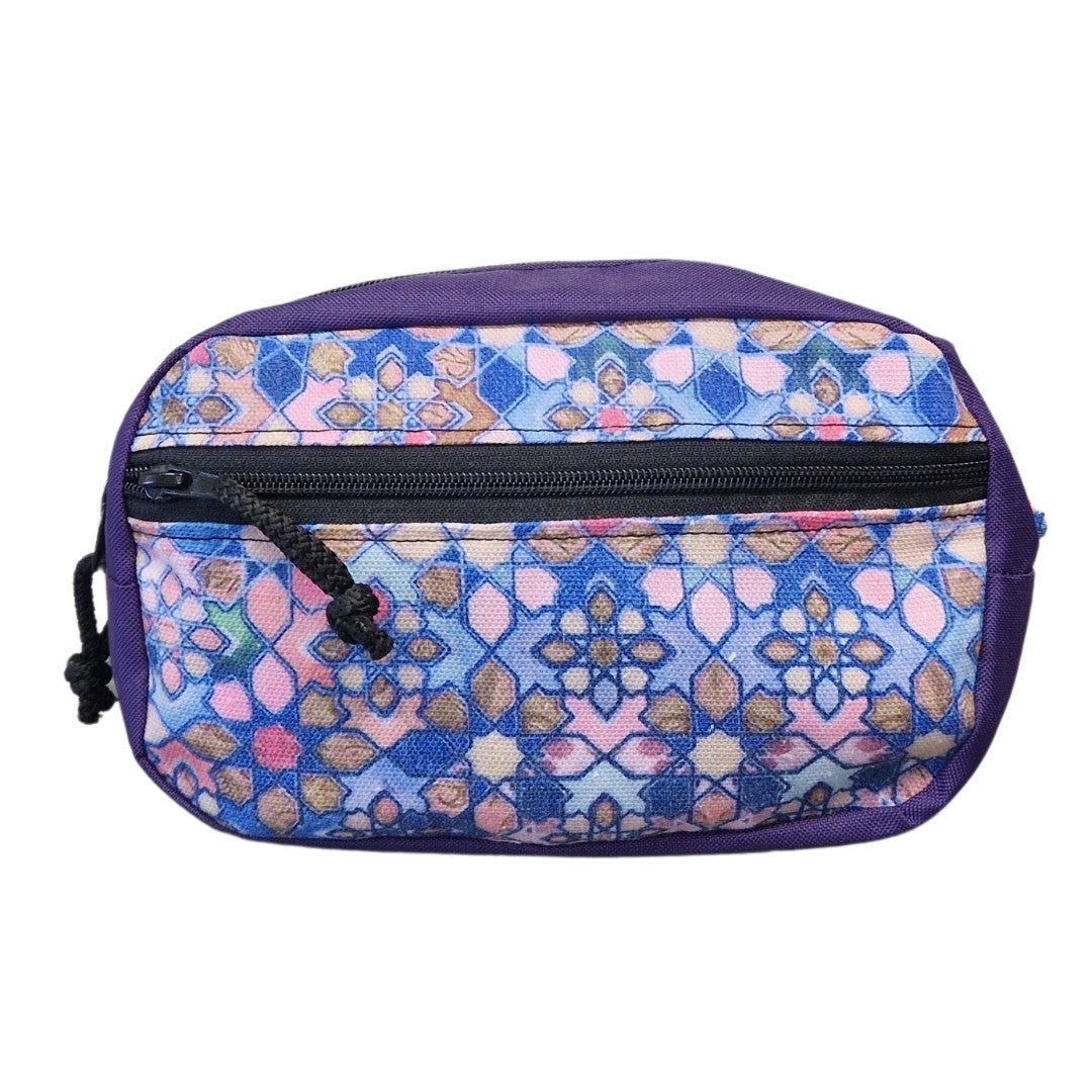 a soft grey water-resistant waist bag held gently in hand, showing its comfortable adjustable strap and modern minimalist design