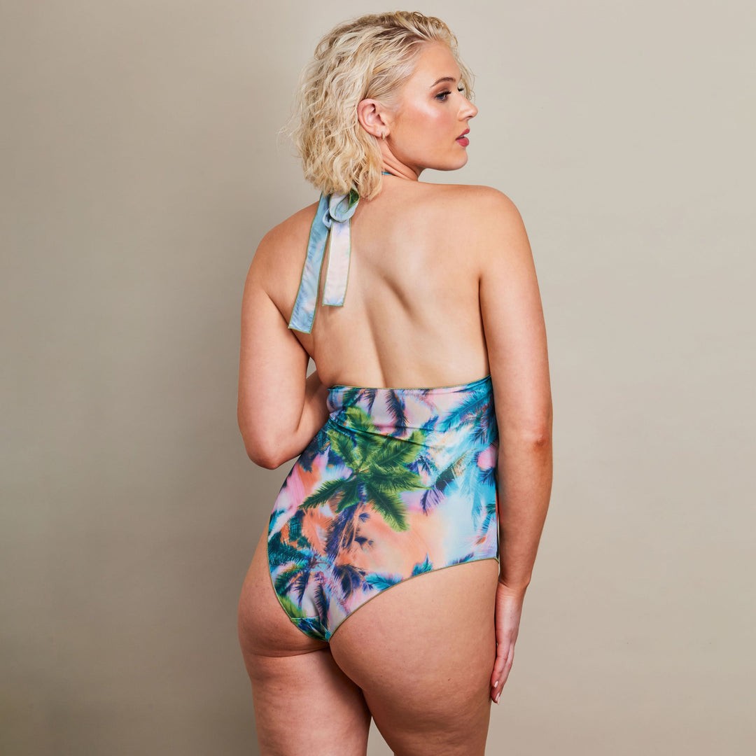 soft morning light on a woman in an electric palm tan-through halterneck swimsuit