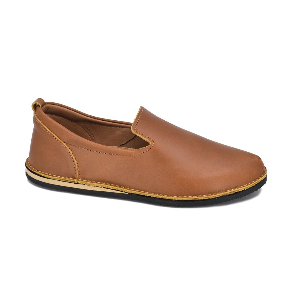 playful ocre leather loafers with natural cork insole, shot in golden sunlight on a cobblestone street