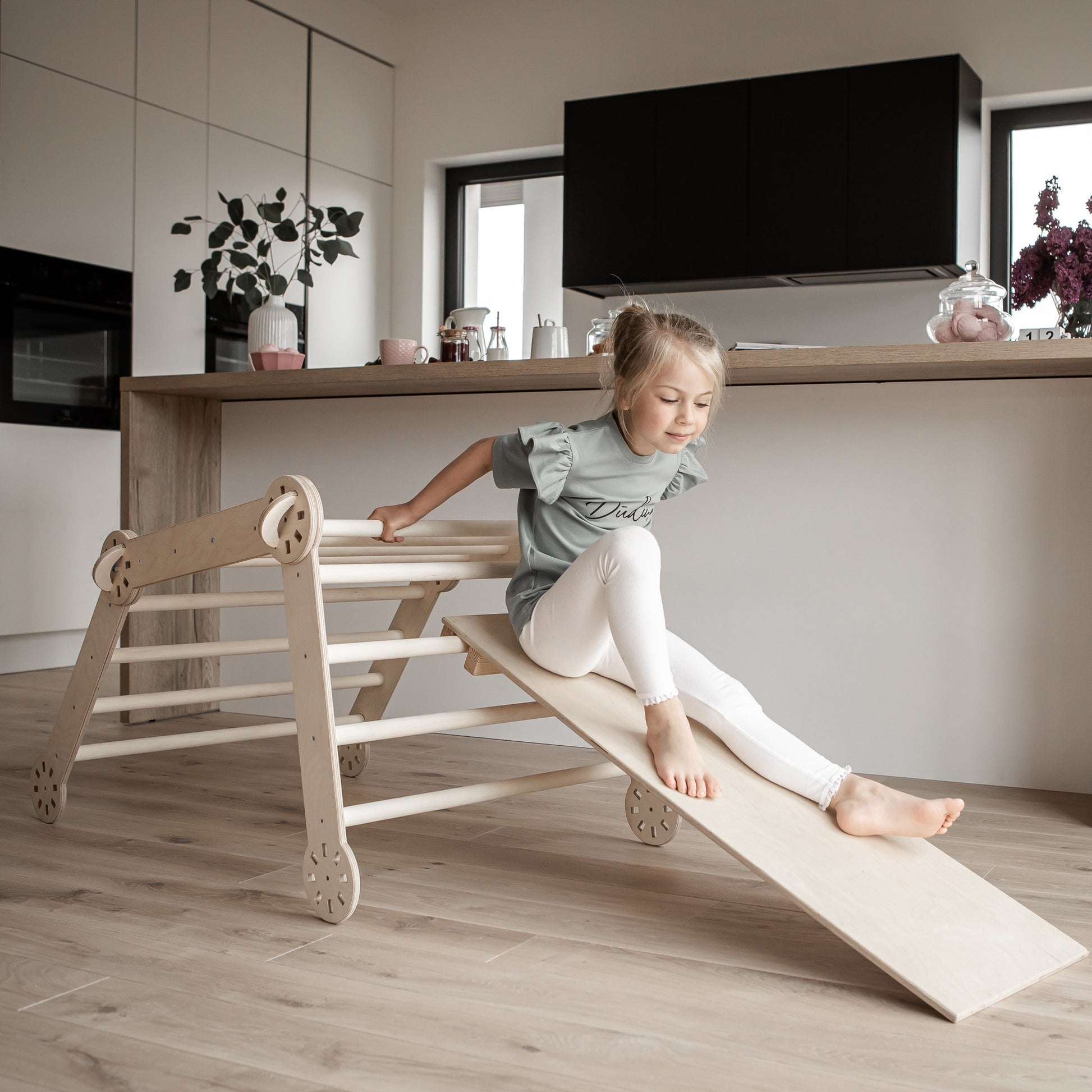 soft-lit montessori climber with ramp folded neatly beside a cozy play mat, ready for quiet indoor adventures