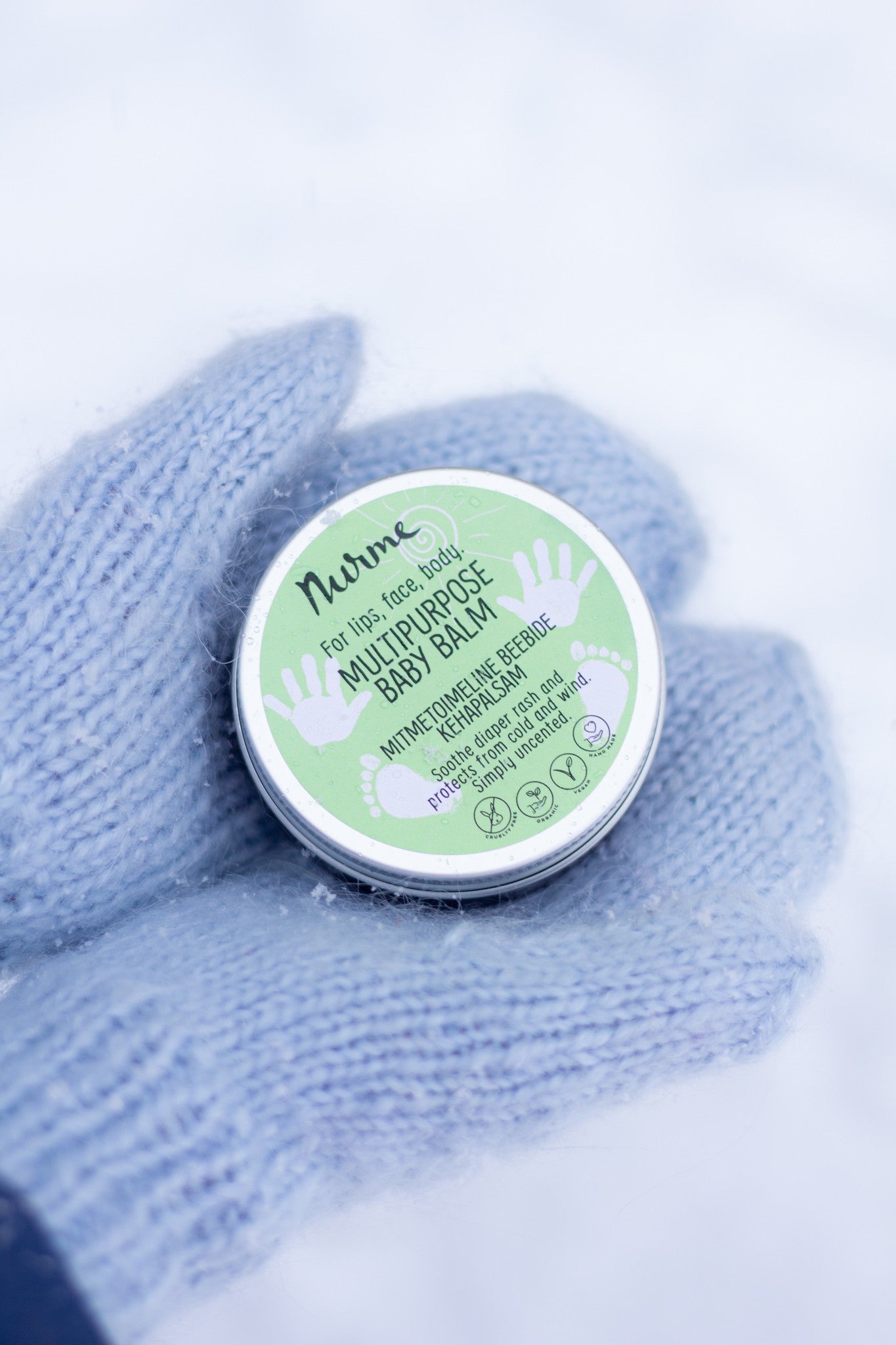 a playful close-up of organic baby balm being playfully scooped with a tiny wooden spatula