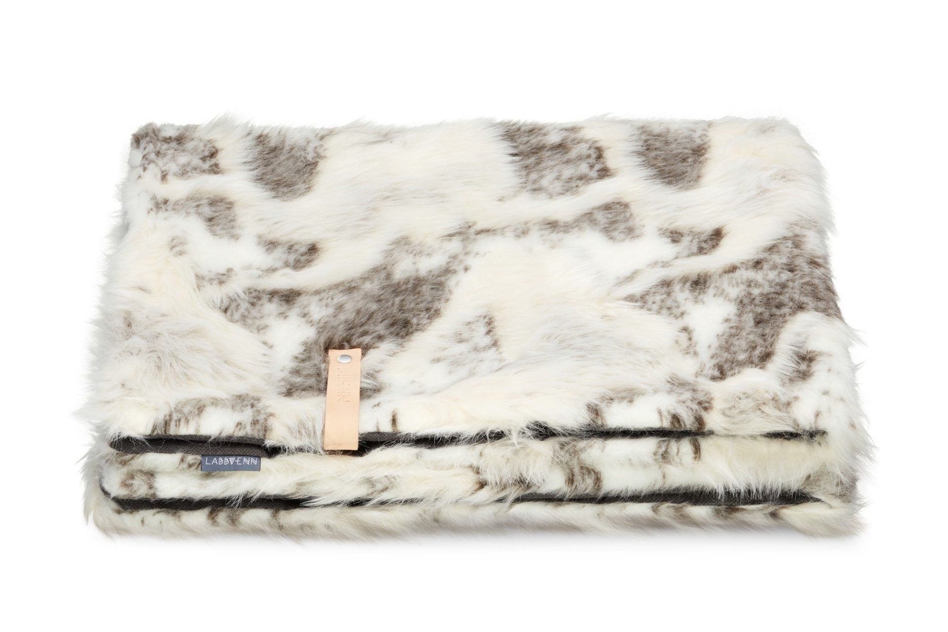 soft brown and white tosse blanket draped invitingly over a cozy chair