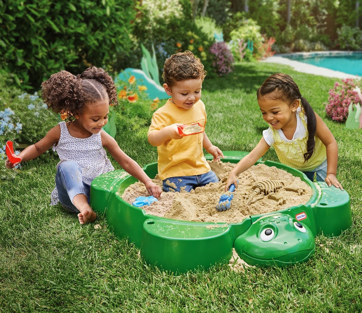 bold green turtle sandbox with shell lid open, ready for play in sunny backyard