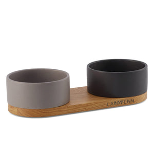 bold black and cocoa ceramic double pet bowl on an elegant oak wood stand