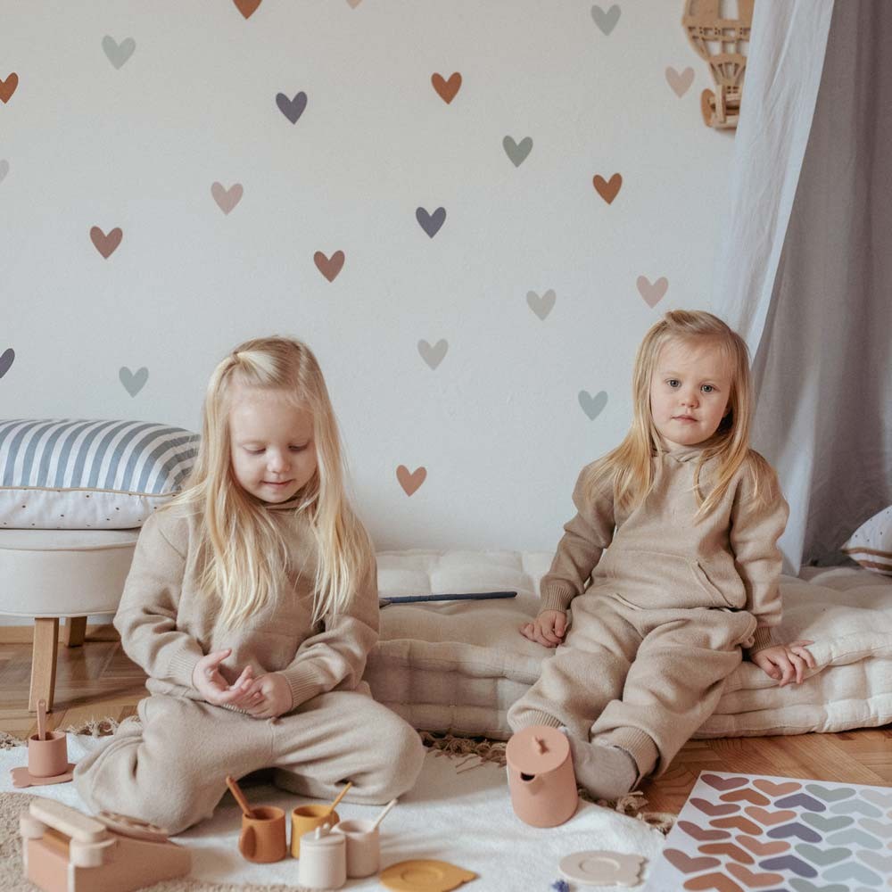 a soft cluster of cappuccino and blue heart stickers arranged above a bed for a cozy, comforting nursery accent
