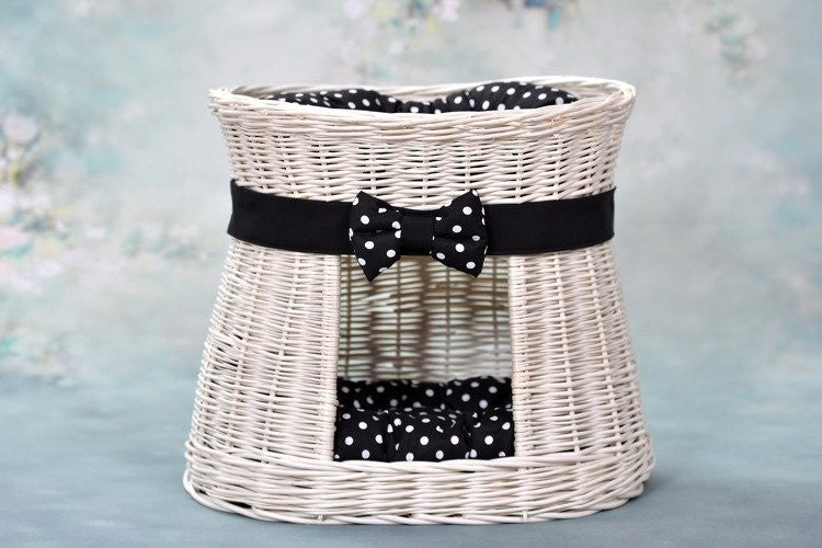 elegant whitewashed wicker cat house with plush cushions in a refined home setting