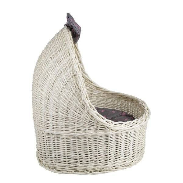 a playful kitten peeking from a whitewashed wicker house with a decorative bow