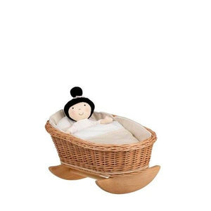 bold wicker rocking cradle mimi with white bedding in dramatic studio lighting