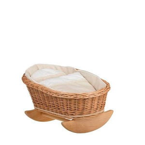 softly lit wicker doll cradle with plush white bedding in a cozy nursery corner