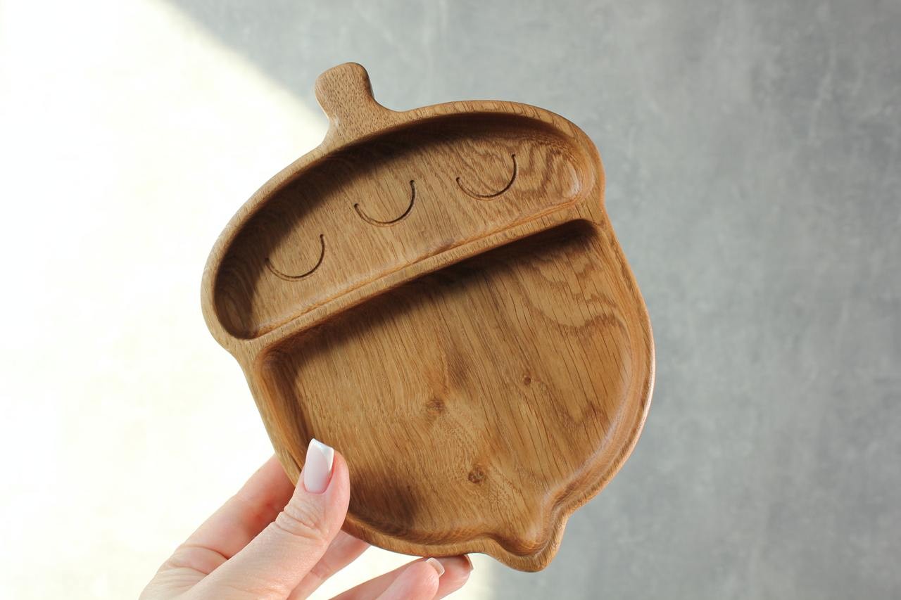 soft-lit handmade oak kids plate with smooth finish, resting on a cozy linen tablecloth