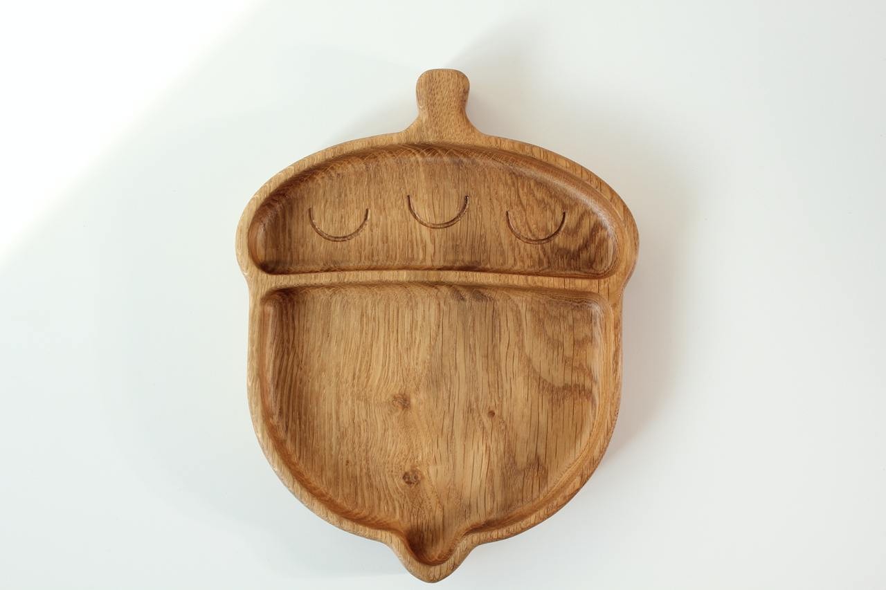 playful acorn-shaped wooden plate for kids on a sunlit table, showcasing smooth hand-polished oak surface