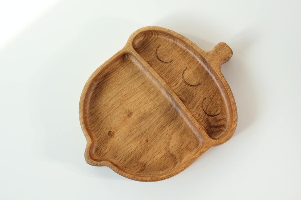 elegant hand-polished oak acorn plate for kids with smooth finish, resting on a rustic wooden table