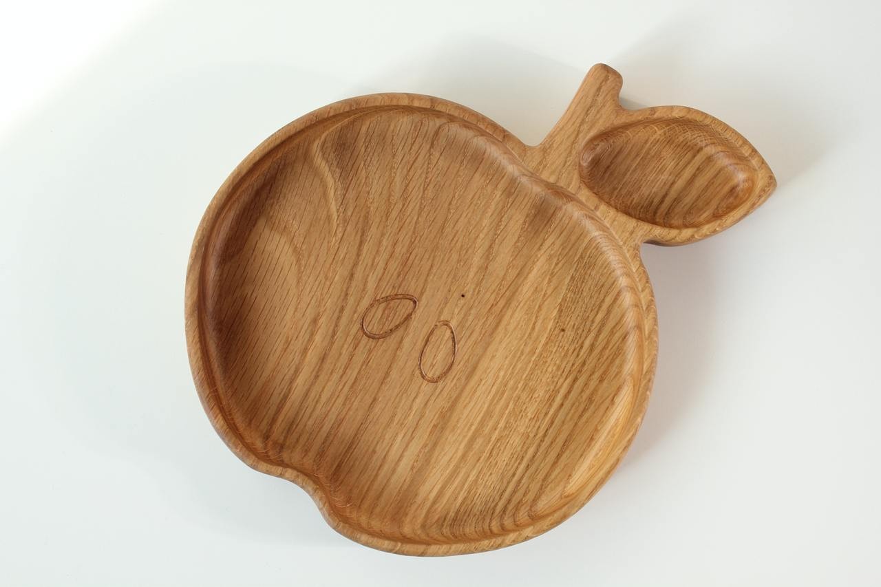 soft-lit wooden kids plate with apple design, hand-polished oak surface, cozy and safe for baby meals