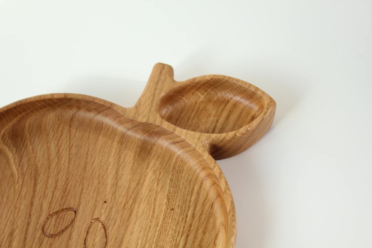 hand-polished wooden apple plate for kids on a rustic table, showcasing natural oak grain and eco-friendly design