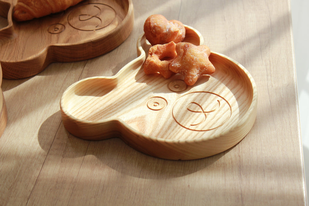 playful wooden bear plate for kids on a sunlit table, showcasing its charming carved details