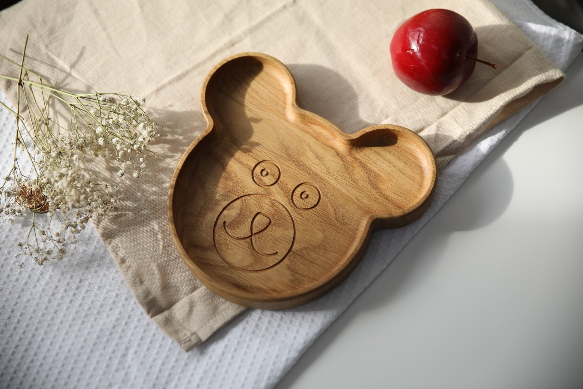 handmade wooden bear plate for kids on a rustic table in warm morning light