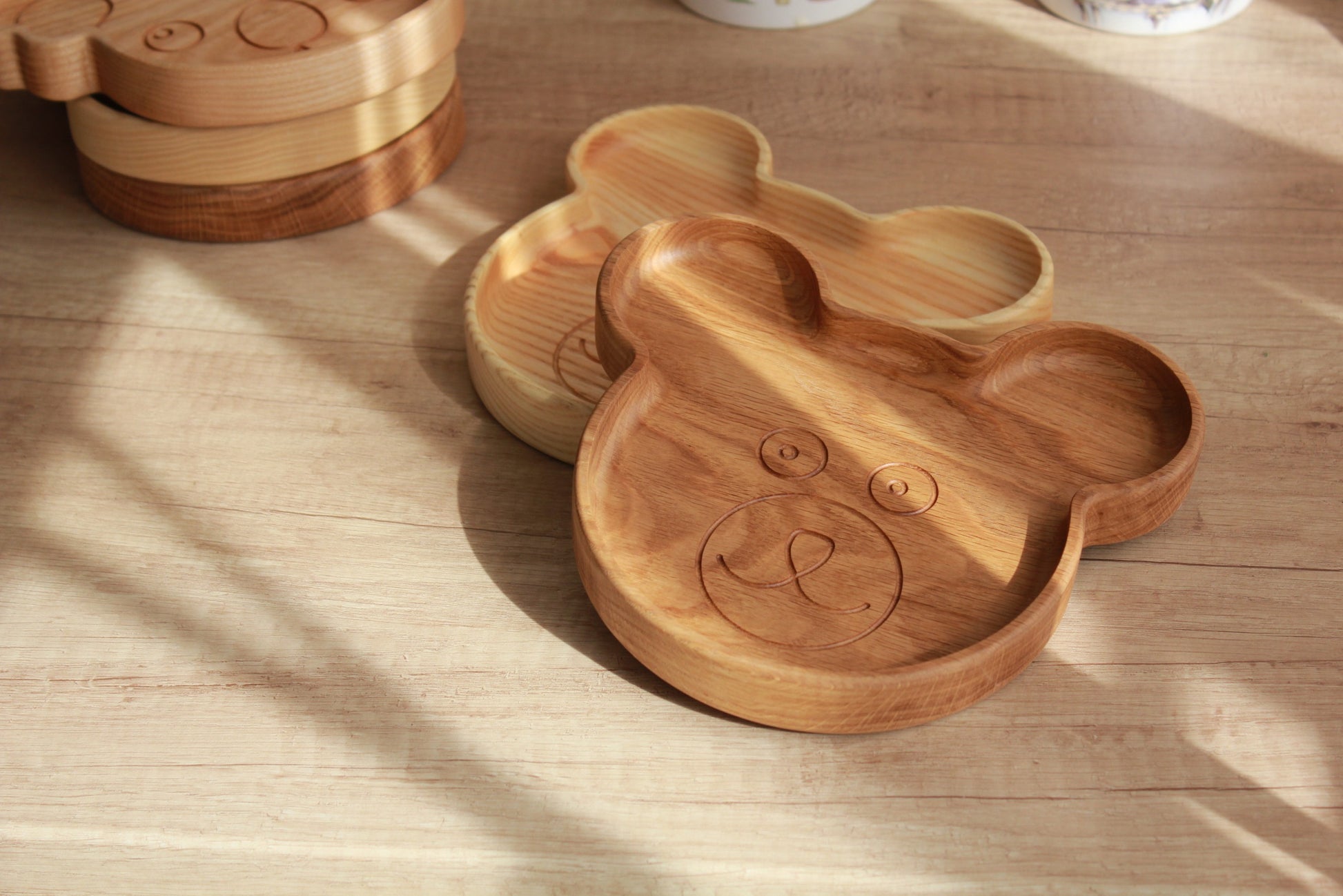 a playful wooden bear plate for kids on a rustic table, showcasing its smooth hand-polished finish