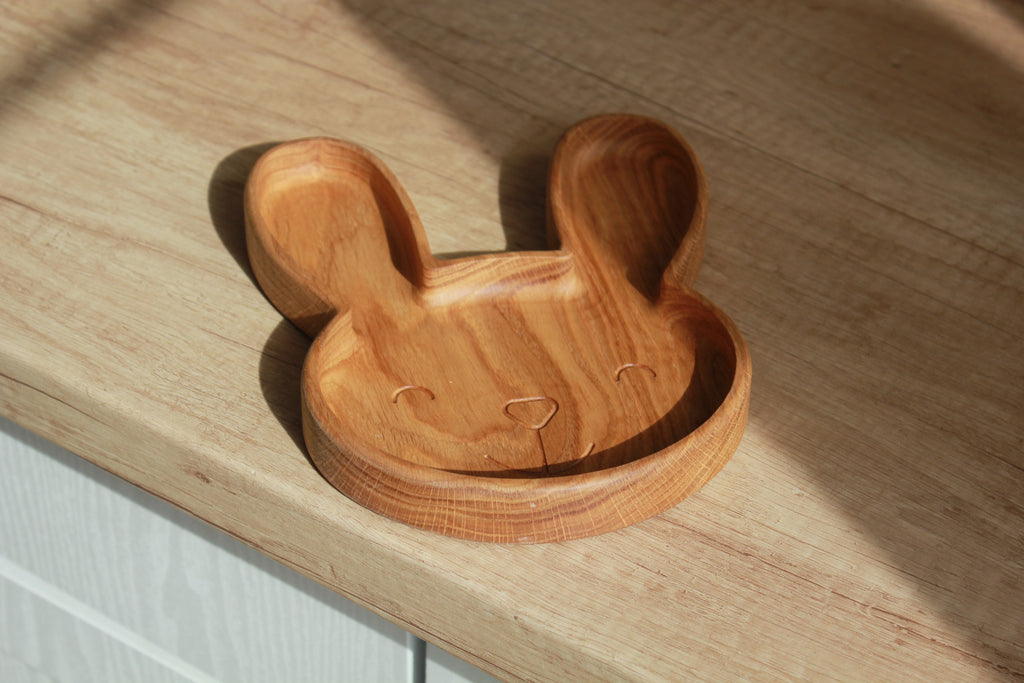 playful bunny wooden plate for kids on a sunlit table, showcasing smooth hand-polished oak and cute engraved details