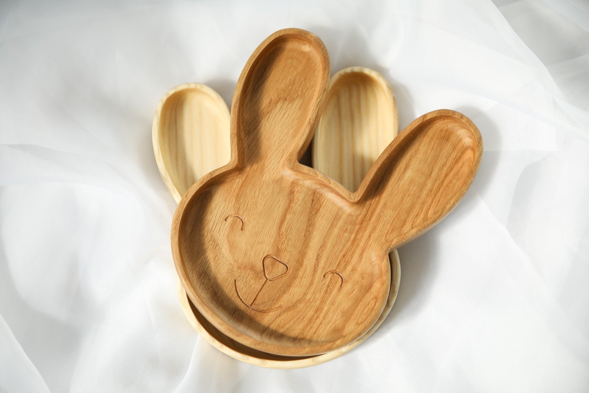 handmade wooden bunny plate for kids on a neutral background, showcasing its smooth finish and practical size