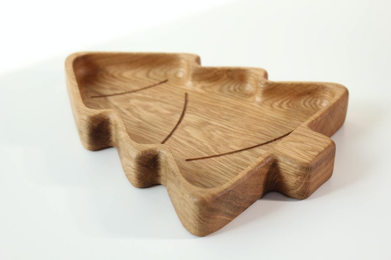 softly lit handmade wooden christmas tree plate for kids, smooth oak surface with warm natural glow