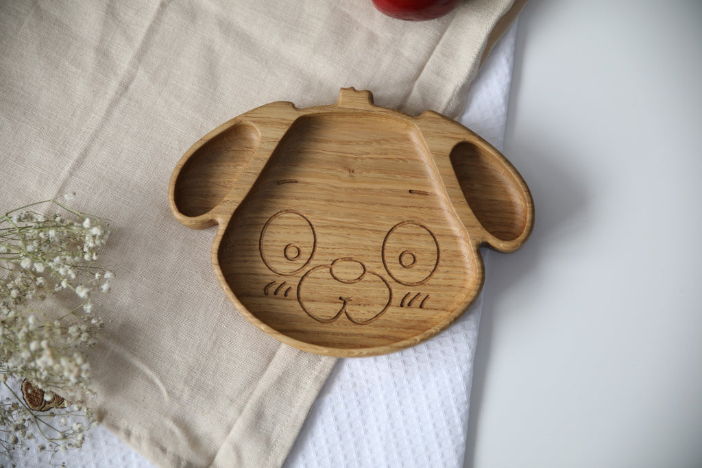 playful dog-shaped wooden plate for kids on a sunny table, handmade from natural oak with smooth polished surface