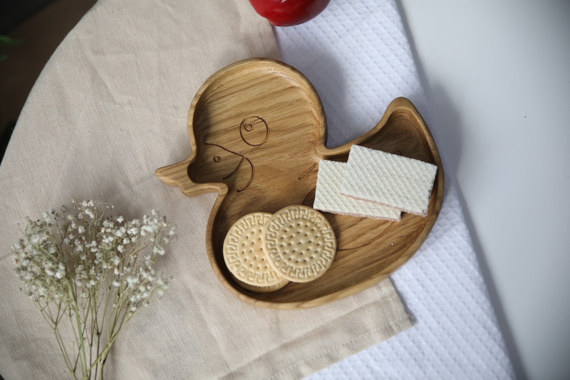 soft-lit wooden duckling plate for kids, hand-polished oak with smooth edges, resting on a cozy kitchen table