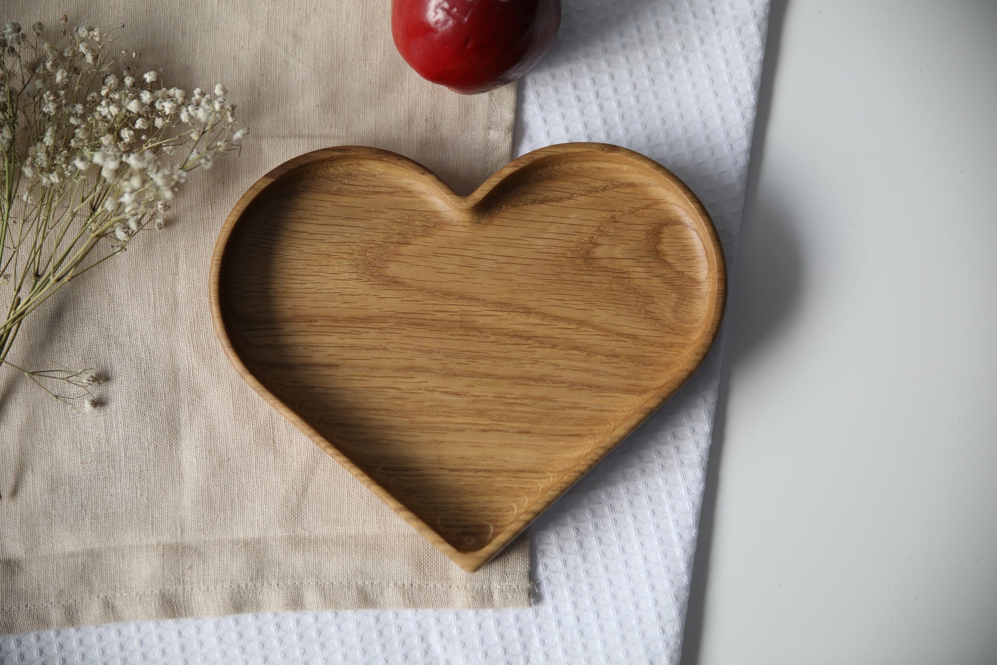 confident close-up of a handcrafted oak heart plate for kids on a dark wood table